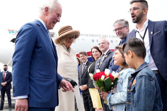 Prince Charles and Camilla receive flowers as they are greeted on the arrival in St. John's