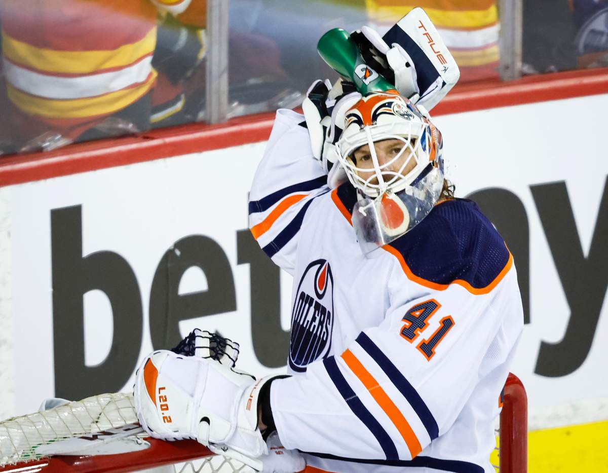 Edmonton Oilers goalie Mike Smith cools off with water after letting in a goal during first period NHL second round playoff hockey action against the Calgary Flames in Calgary, Wednesday, May 18, 2022.THE CANADIAN PRESS/Jeff McIntosh