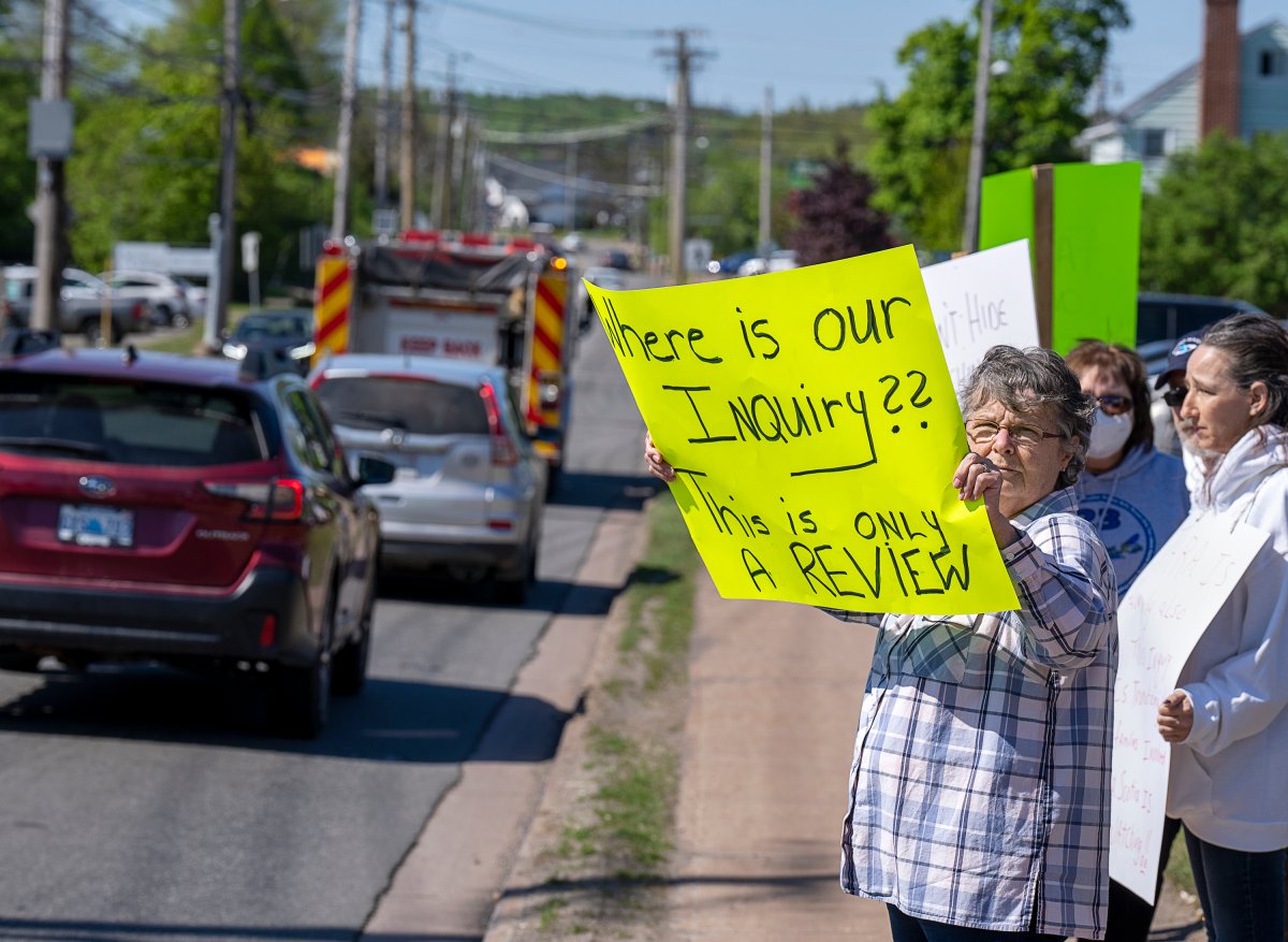 Family and friends of the victims protest outside the hotel where the Mass Casualty Commission inquiry into the mass murders in rural Nova Scotia on April 18/19, 2020, is being held in Truro, N.S. on Thursday, May 26, 2022. THE CANADIAN PRESS/Andrew Vaughan.