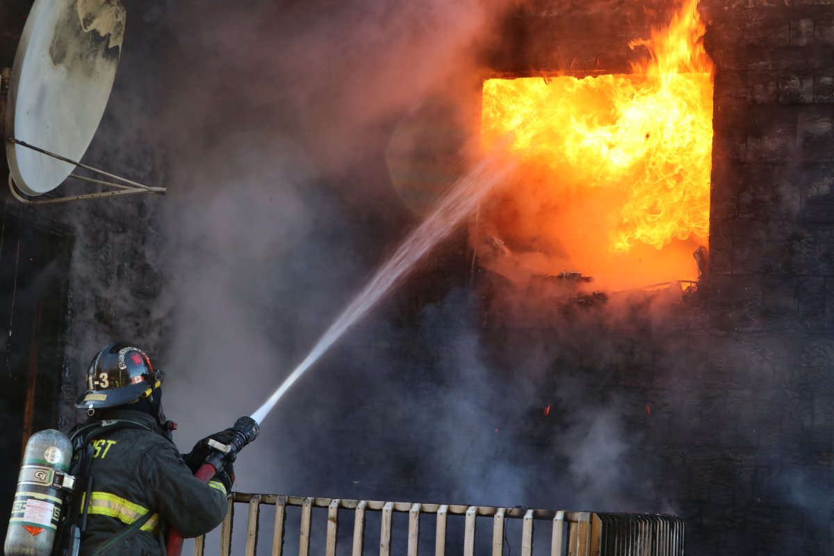 A firefighter fights a blaze that destroyed a home and sent two people to hospital Saturday morning.