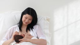 A mother breast feeding her newborn baby girl.