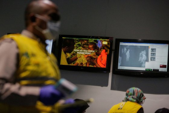 A health officer stands in front of a monkeypox virus information at Soekarno-Hatta International Airport in Tangerang near Jakarta, Indonesia on May 15, 2019.