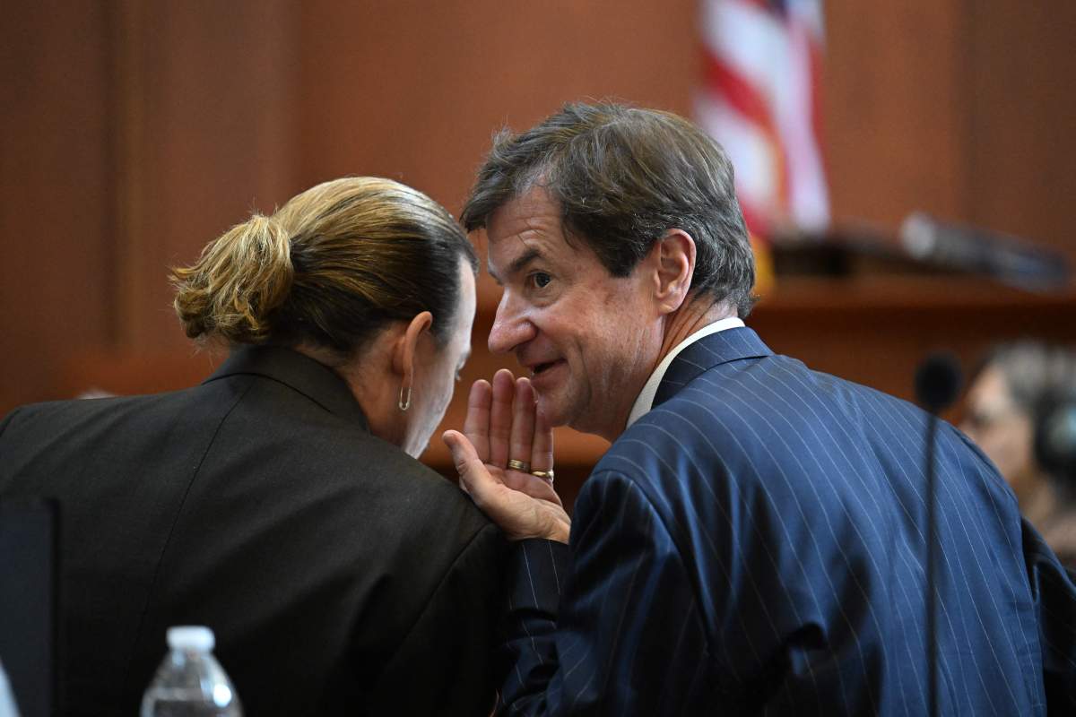 US actor Johnny Depp speaks to his attorney Ben Chew in the courtroom at the Fairfax County Circuit Court in Fairfax, Virginia, on May 3, 2022.