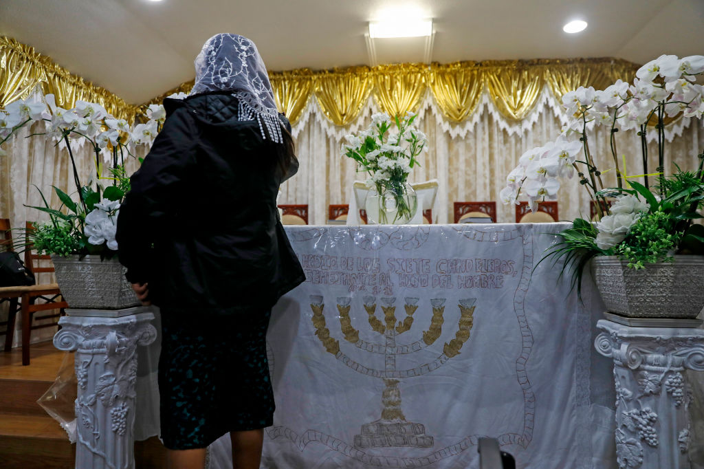 A parishioner puts money into a donation box at the Iglesia Evangelica Apostoles y Profetas church in San Jose, Calif., on Sunday, May 8, 2022. The church, located in a backroom of a multi-family home on the 1000 block of 2nd Street, is at the center of an exorcism death of a 3-year-old and the kidnapping of a young baby.