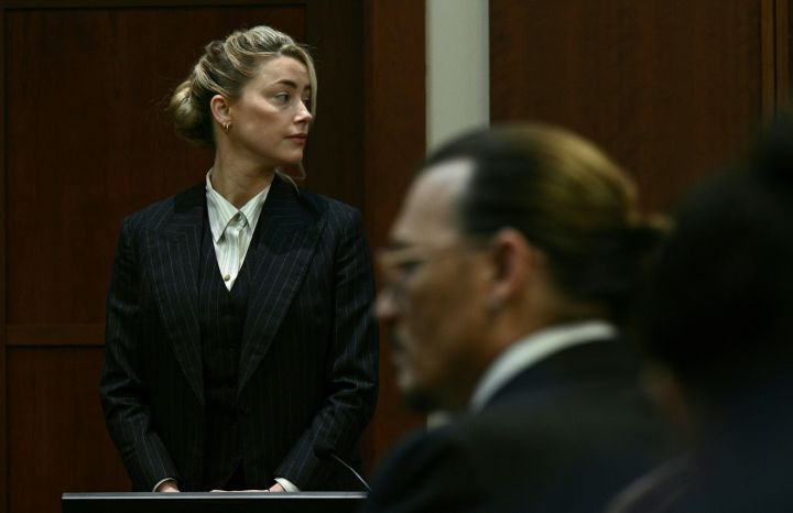 Actors Amber Heard and Johnny Depp watch as the jury comes into the courtroom after a lunch break at the Fairfax County Circuit Courthouse in Fairfax, Virginia, on May 17, 2022.