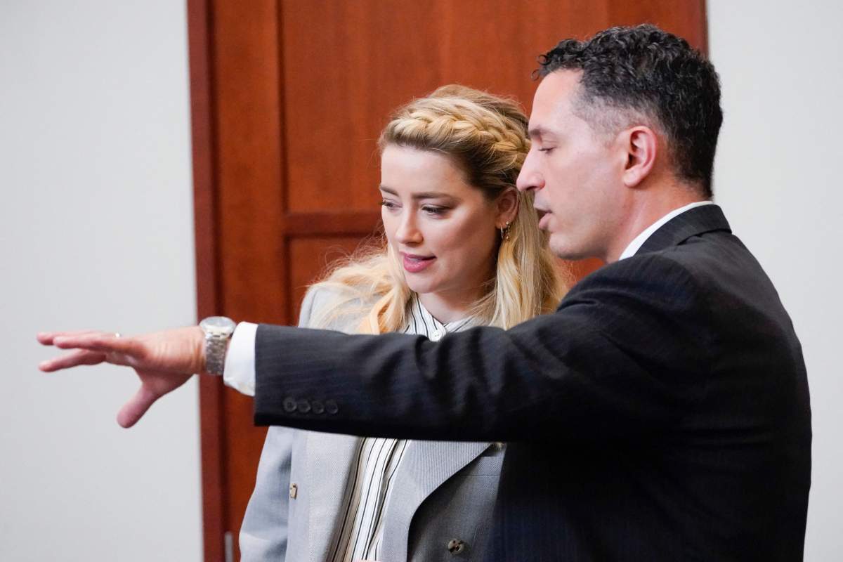 Actor Amber Heard speaks with her legal team in the courtroom at the Fairfax County Circuit Courthouse in Fairfax, Virginia, on May 27, 2022.