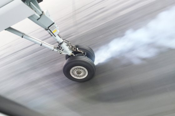 High angle view of smoke emitting from airplane wheel while landing on runway