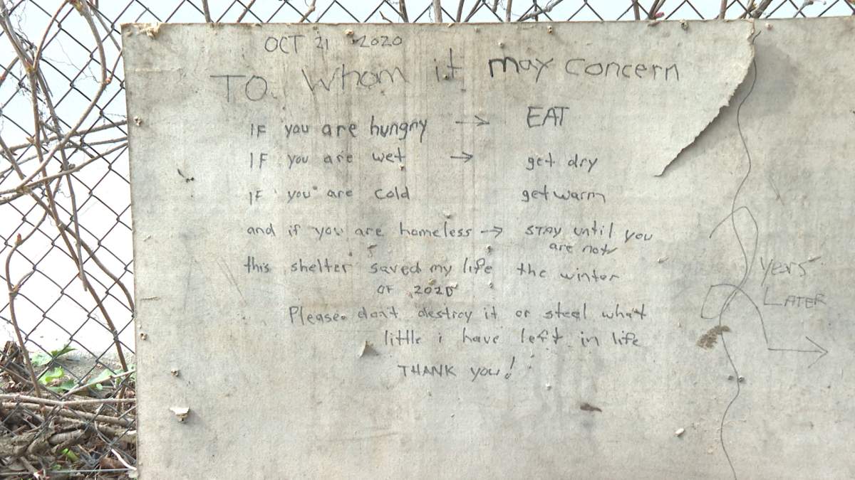 A sign left in the woods by the hut builder, welcoming those in need to use his shelter.