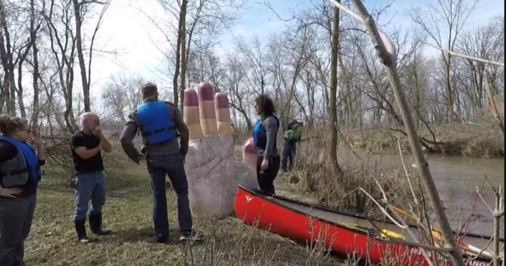 Paddlers locate giant hand statue carried away by swollen river in Winnipeg