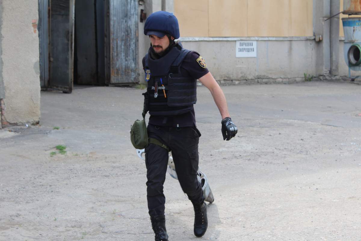 An emergency worker drags away a spent rocket found on a roof in Kharkiv, May 20, 2022.
