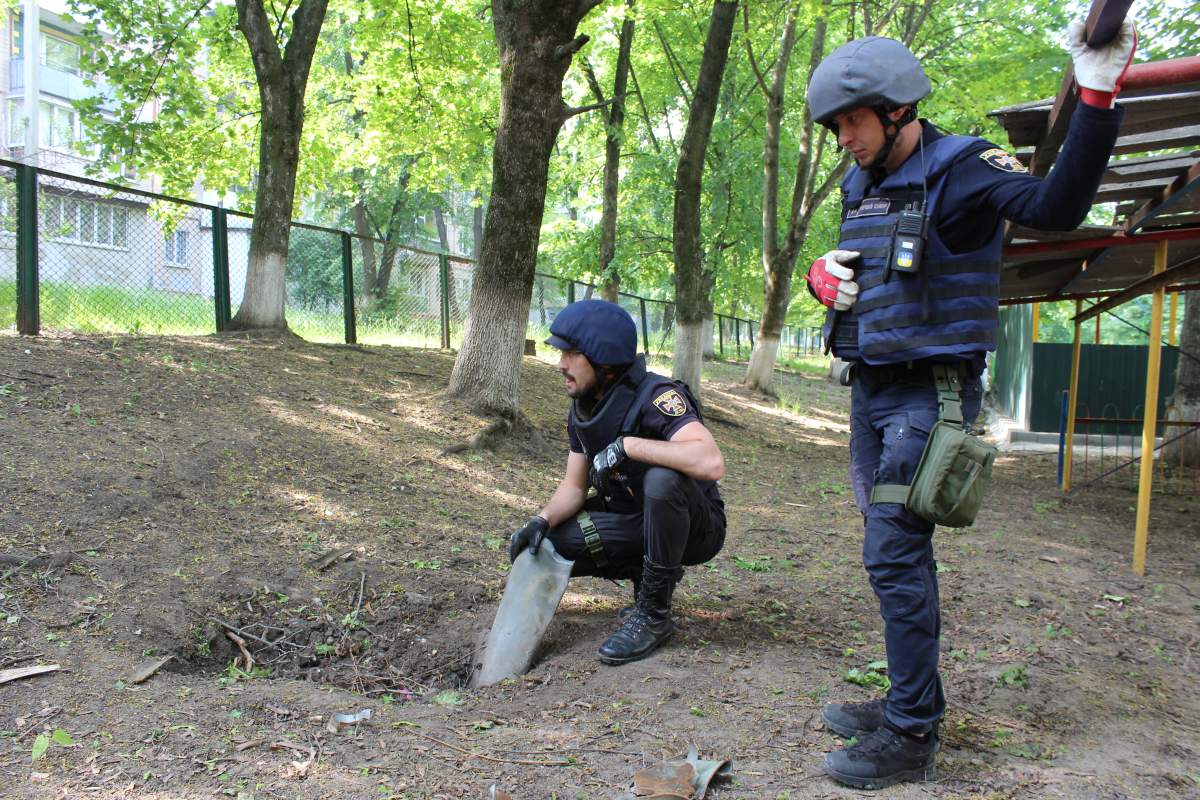 Workers dig a Russian rocket fragment out of a playground in Kharkiv, May 20, 2022.