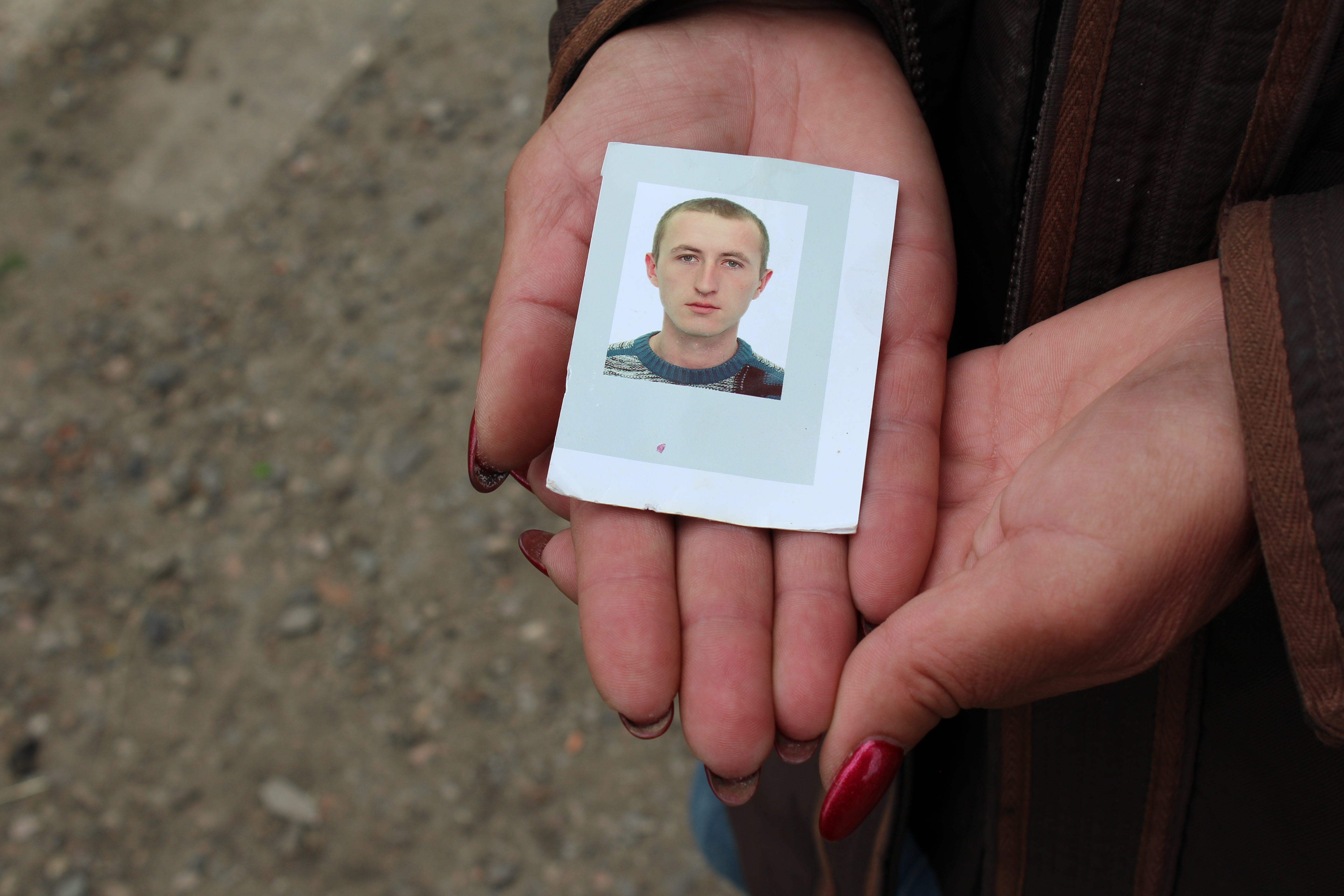 His mother holds a photo of Olexi Kettler, killed by Russian shelling on April 21, 2022.