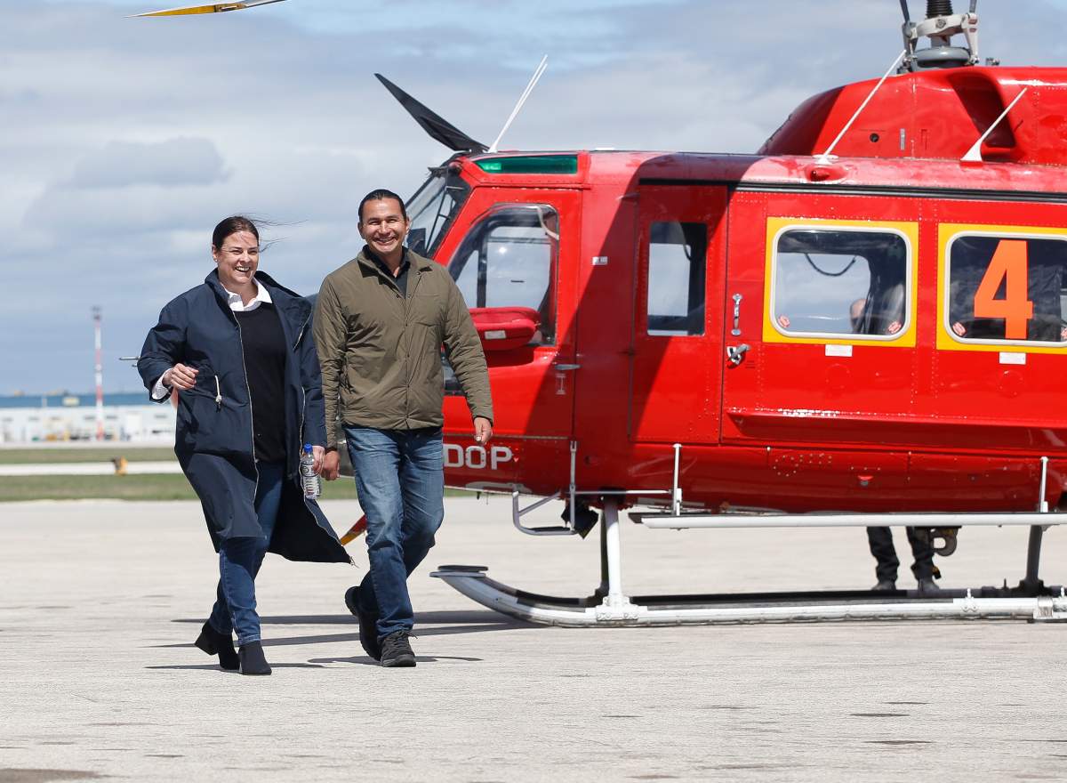 Premier Heather Stefanson and Opposition Leader Wab Kinew head to a press conference after a helicopter tour of Manitoba’s flood area at the Winnipeg airport, Sunday, May 15, 2022.