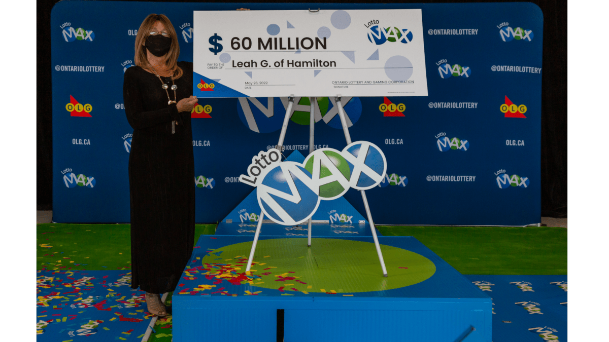 Lotto Max winner Leah Murdoch-Gerics from Hamilton stands beside a large cheque she will soon be able to cash for $60 million. 