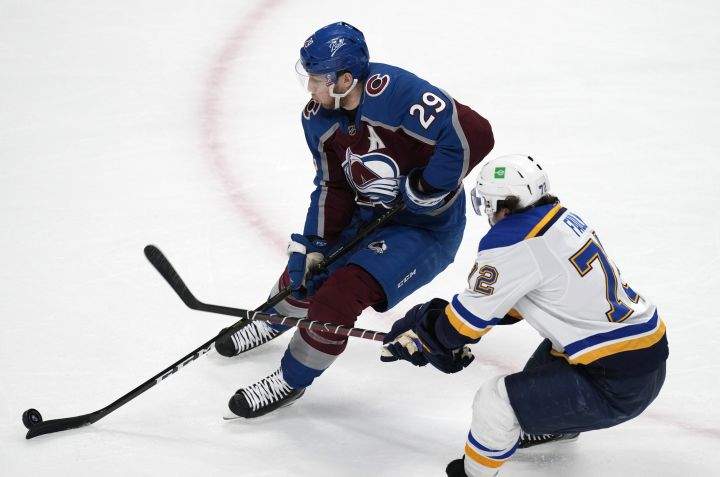 Colorado Avalanche center Nathan MacKinnon, left, drives to the net with St. Louis Blues defenseman Justin Faulk in pursuit during the first period of Game 5 of an NHL hockey Stanley Cup second-round playoff series Wednesday, May 25, 2022, in Denver.
