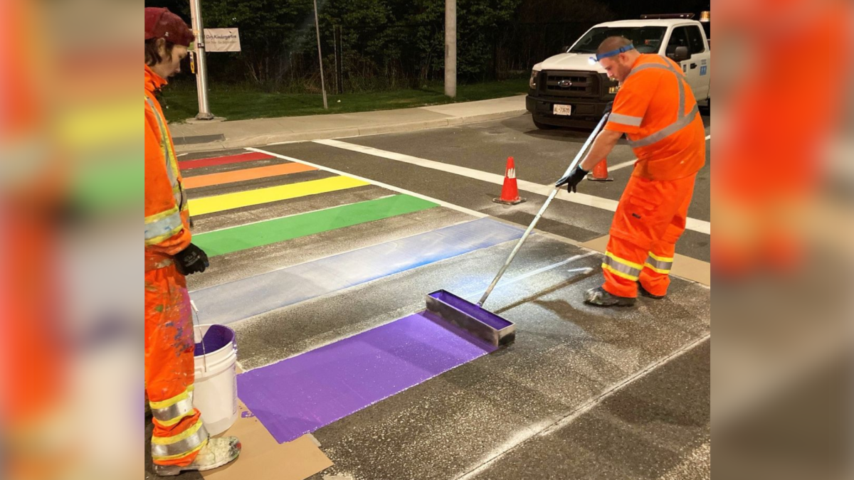 City of Hamilton workers painting the Pride crosswalk in Waterdown.