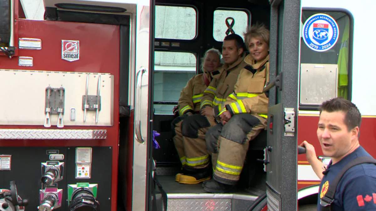 Calgary Coun. Evan Spencer and Mayor Jyoti Gondek (centre) is seen on a on a fire truck on May 30, 2022, as part of a training experience.