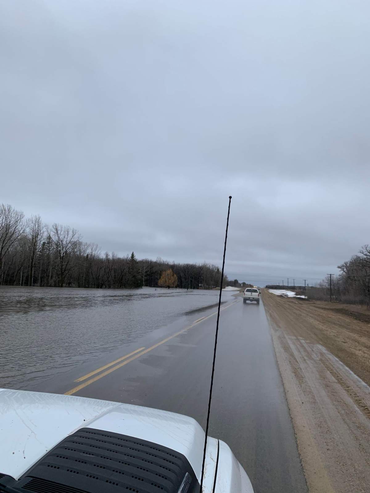 A photo taken Sunday morning showing water creeping over Provincial Road 245 west of Carman.
