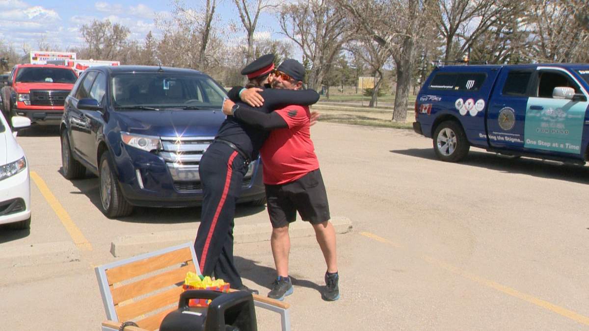 Chad Kennedy former Alberta first responder at Columbia Icefield bus crash gives a hug to Inspector Kimberley Pasloske at Sea-to-Sea walk for PTSD awareness
