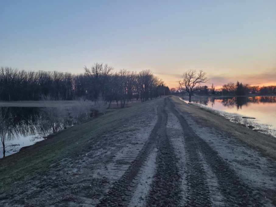 A photo of the south dyke at Prairie Oak Campground near Emerson, Man., showing the runoff from the Red River on the right, and the campground’s swimming pond and beach on the left.