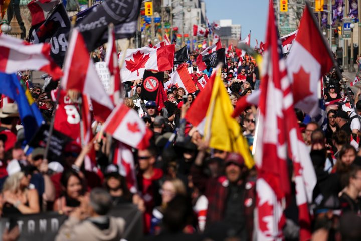 Protesters gather and wave flags during a demonstration, part of a convoy-style protest participants are calling “Rolling Thunder”, in Ottawa, Saturday, April 30, 2022.