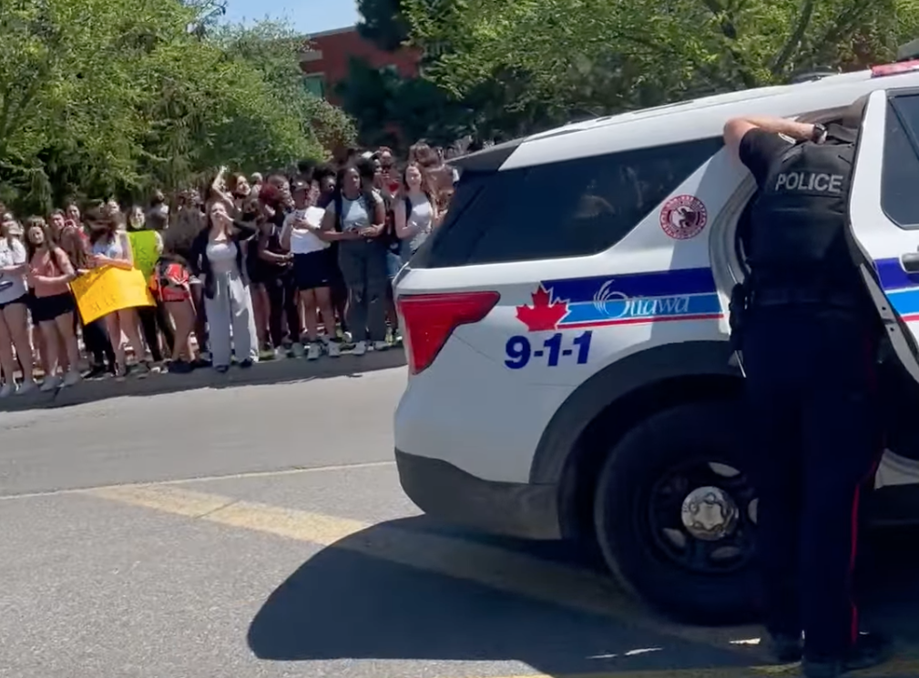 A still from social media video shows police at the site of a student protest outside Béatrice-Desloges Catholic High School in Ottawa on May 13, 2022.