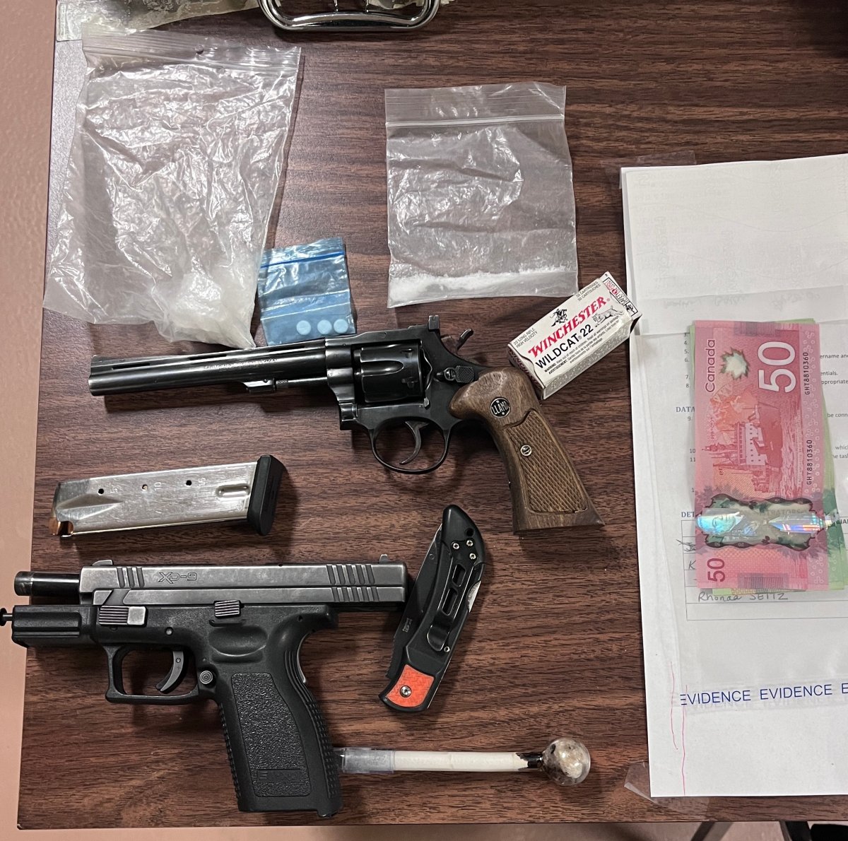 RCMP handout photo shows drugs, firearms, and cash they say was found after a man wanted in Manitoba and Saskatchewan was arrested in Winnipeg.