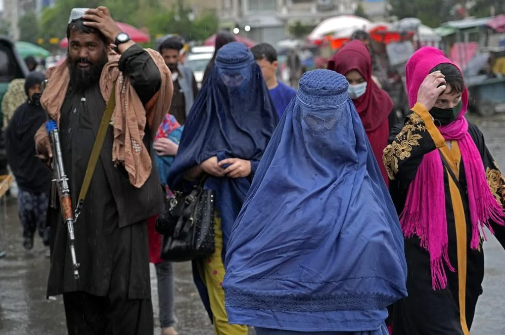 Afghan women walk through the old market