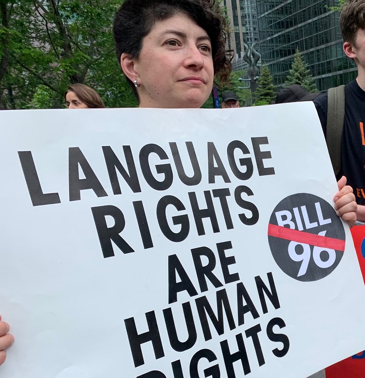 A person holds a sign at a rally against Quebec’s newly-adopted language law. Thursday, May 26, 2022.