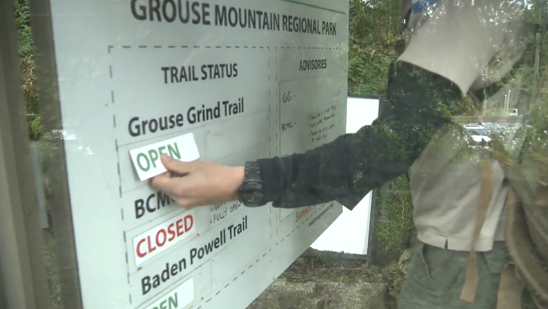A Metro Vancouver parks worker opens the Grouse Grind for the first day of the 2022 season. 