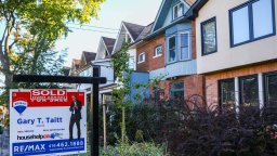 A sold sign is visible outside a line of Toronto area row homes.