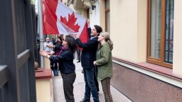 Prime Minister Justin Trudeau raises a flag at the Canadian embassy in Kyiv during a surprise trip.