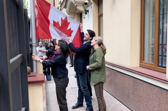 Prime Minister Justin Trudeau raises a flag at the Canadian embassy in Kyiv during a surprise trip.