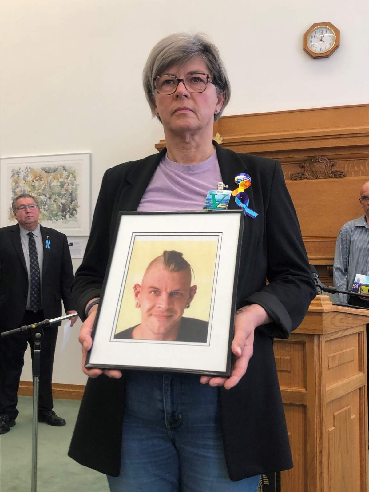 Marilyn Irwin holds a photo of her son MacRae, whom she says was battling substance use disorder and left behind two sons.