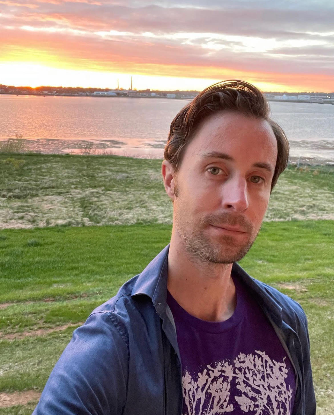 Matt Packman poses on the shore of Charlottetown, PEI, where he currently resides with his husband.