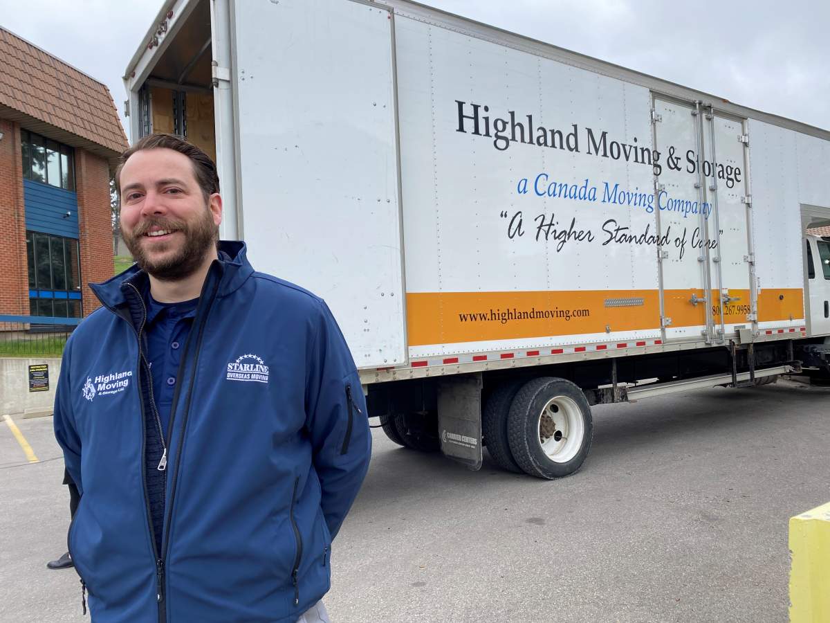 Highland Moving & Storage GM Liam McQuillan stands by one of his trucks