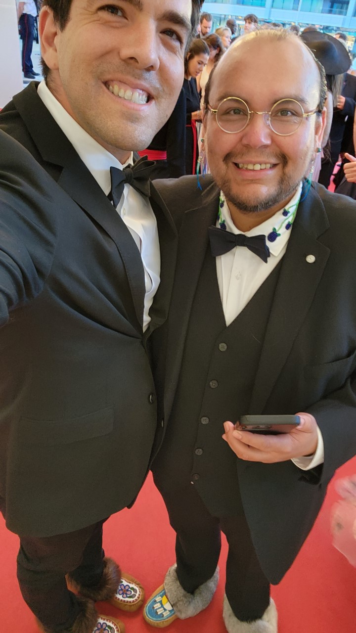 Redvers and another member of his cohort show off their moccasins on the red carpet after meeting with festival organizers and explaining their cultural importance.