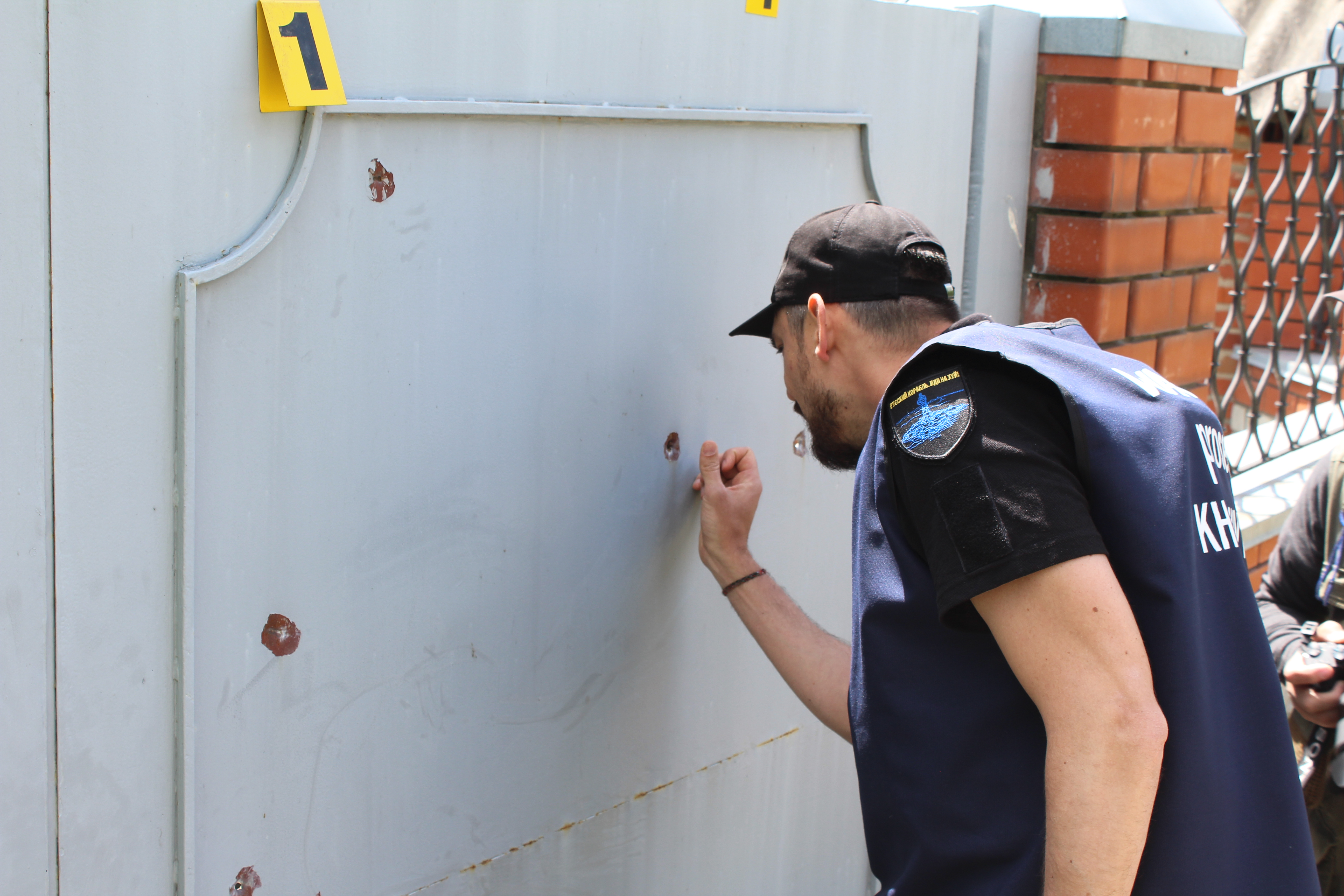 Ukrainian war crimes investigator examines bullet holes at property where man was killed in Mala Rohan, Ukraine, May 23, 2022.