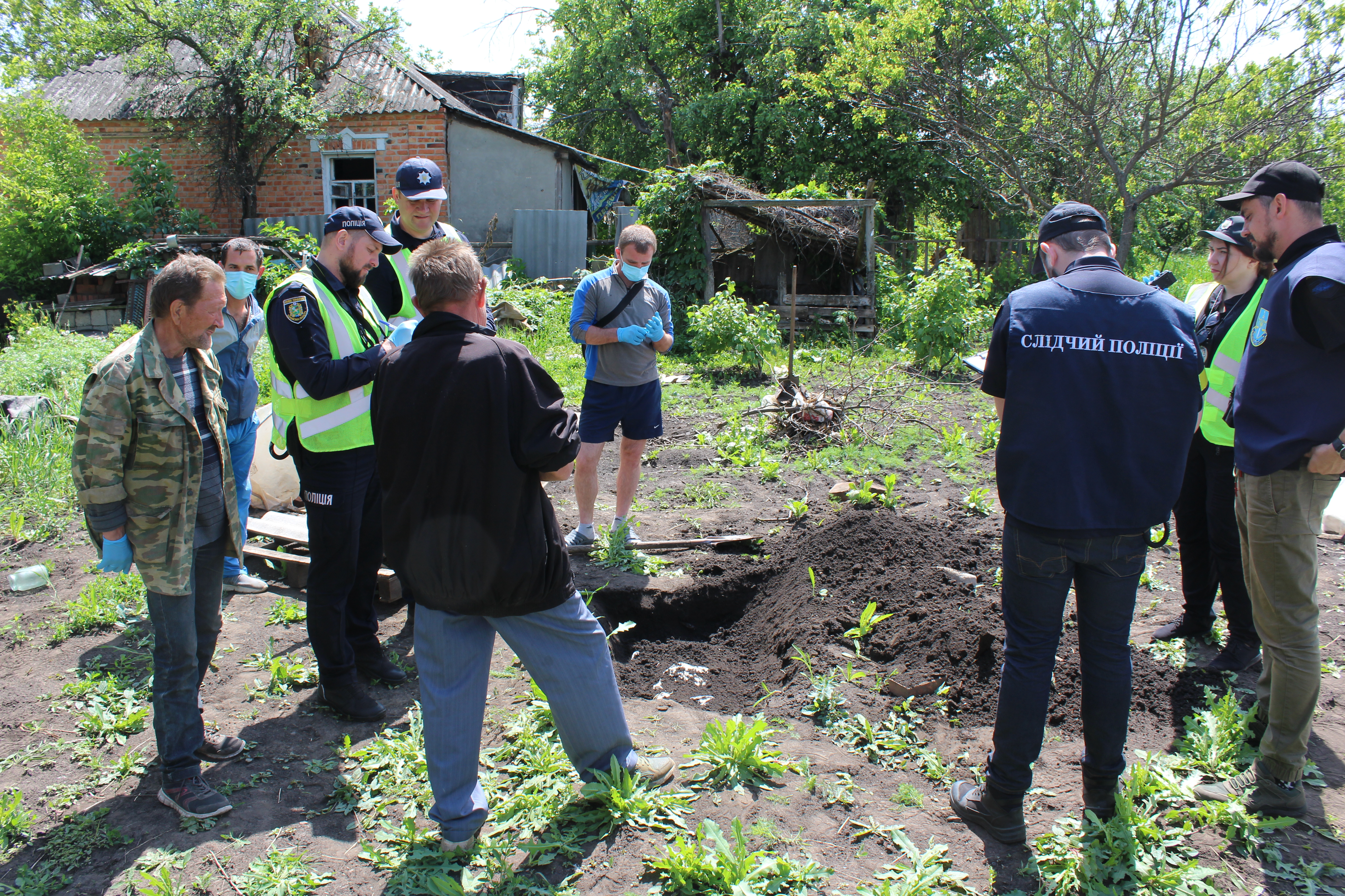 War crimes investigators exhume the remains of a man killed by Russian tank in Mala Rohan, Ukraine. May 23, 2022.