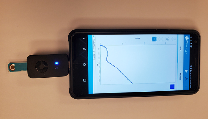 Demonstration photo of an aptamer-based COVID-19 test created by McMaster University researchers using a small sample of saliva, chemical reagent and a smartphone reader.