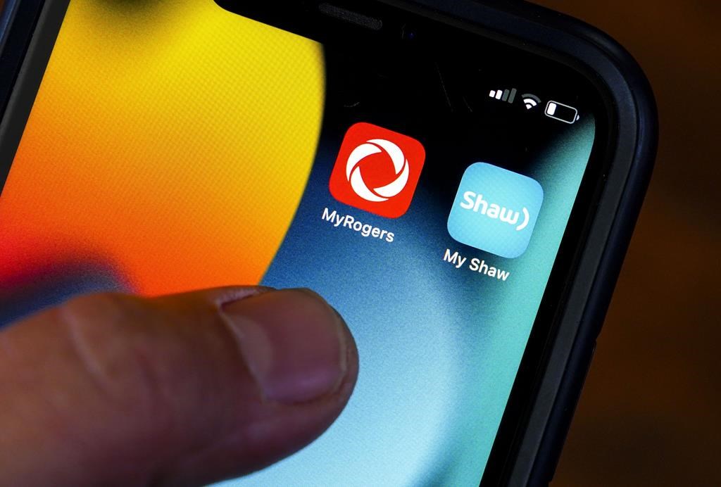 Rogers and Shaw applications are pictured on a cellphone in Ottawa on May 9, 2022. Rogers says the Competition Bureau's opposition to its proposed takeover of Shaw is not supported by the evidence in its filing challening the bureau's stance. THE CANADIAN PRESS/Sean Kilpatrick.