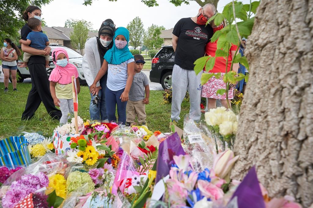 Mourners visit the scene of a hate-motivated vehicle attack in London, Ont., on June 8, 2021. The June 6, 2021, attack left four members of a family dead and their nine-year-old son in hospital. THE CANADIAN PRESS/ Geoff Robins.