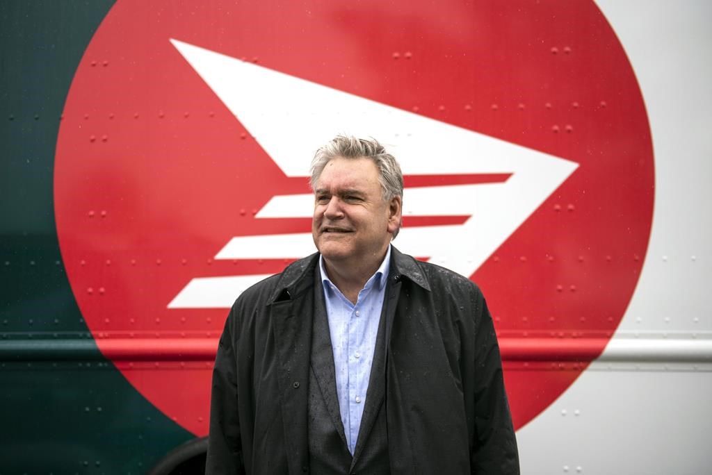 Canada Post CEO Doug Ettinger poses in front of an electric delivery vehicle after a news conference on the postal service’s plans to transform their fleet of 14,000 vehicles, in Ottawa, on June 9, 2022. THE CANADIAN PRESS/Justin Tang.