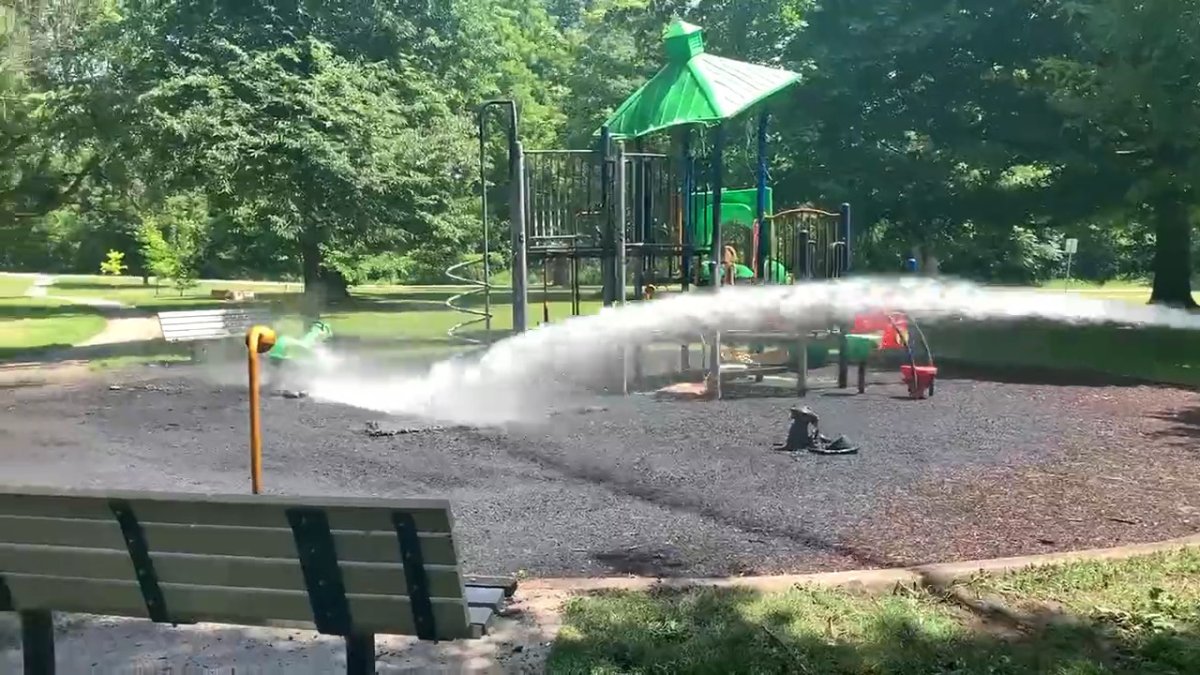 Firefighters douse the playground at London's Richard B. Harrison Park on June 15, 2022.
