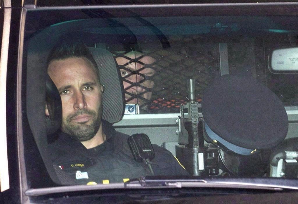 Basil Borutski (back) leaves in a police vehicle after appearing at the courthouse in Pembroke, Ont. on Sept. 23, 2015.