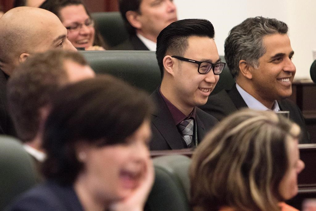 Thomas Dang (centre) laughs along with his colleagues during an introductory meeting with newly elected NDP MLAs in Edmonton on May 12, 2015. The Alberta RCMP has issued a court summons for Independent MLA Thomas Dang, despite the politician saying he is no longer under criminal investigation and will not face criminal charges. THE CANADIAN PRESS/Amber Bracken.