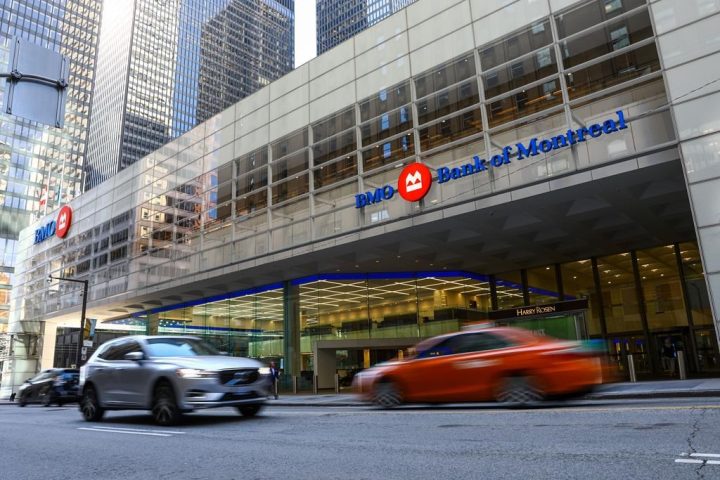 Vehicles pass by the First Canadian Place in the financial district in Toronto on Wednesday, September 29, 2021. 