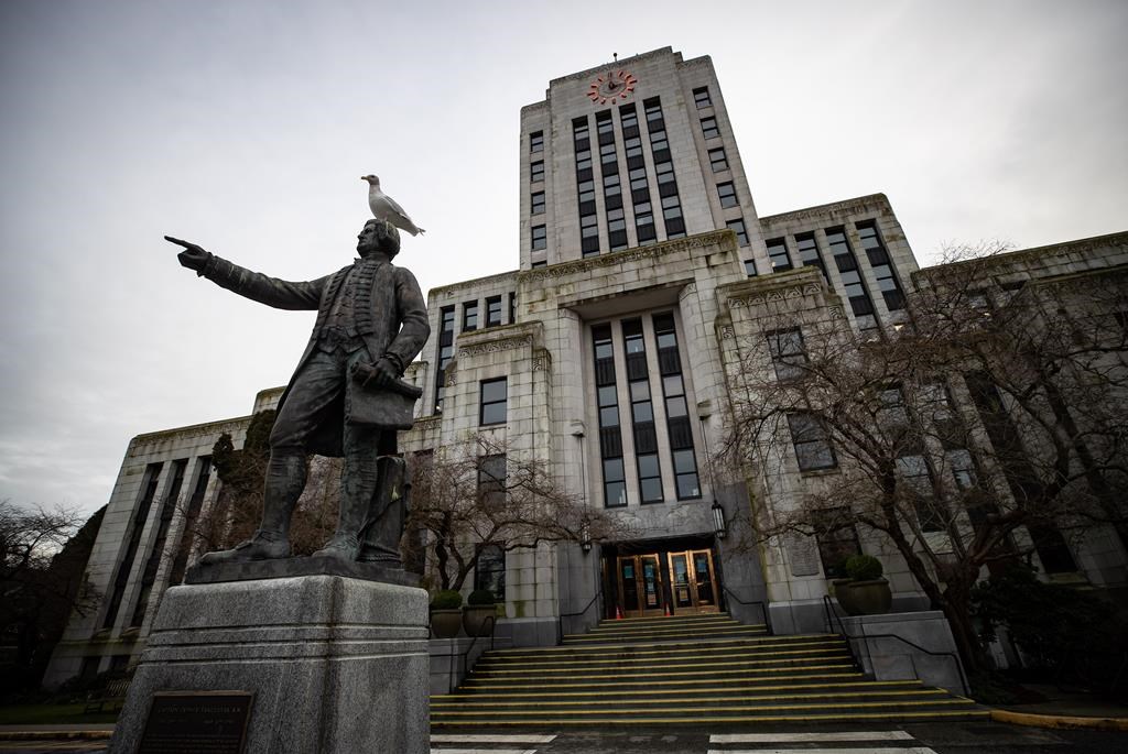 A seagull stands atop a statue of Captain George Vancouver outside Vancouver City Hall, Saturday, Jan. 9, 2021. 