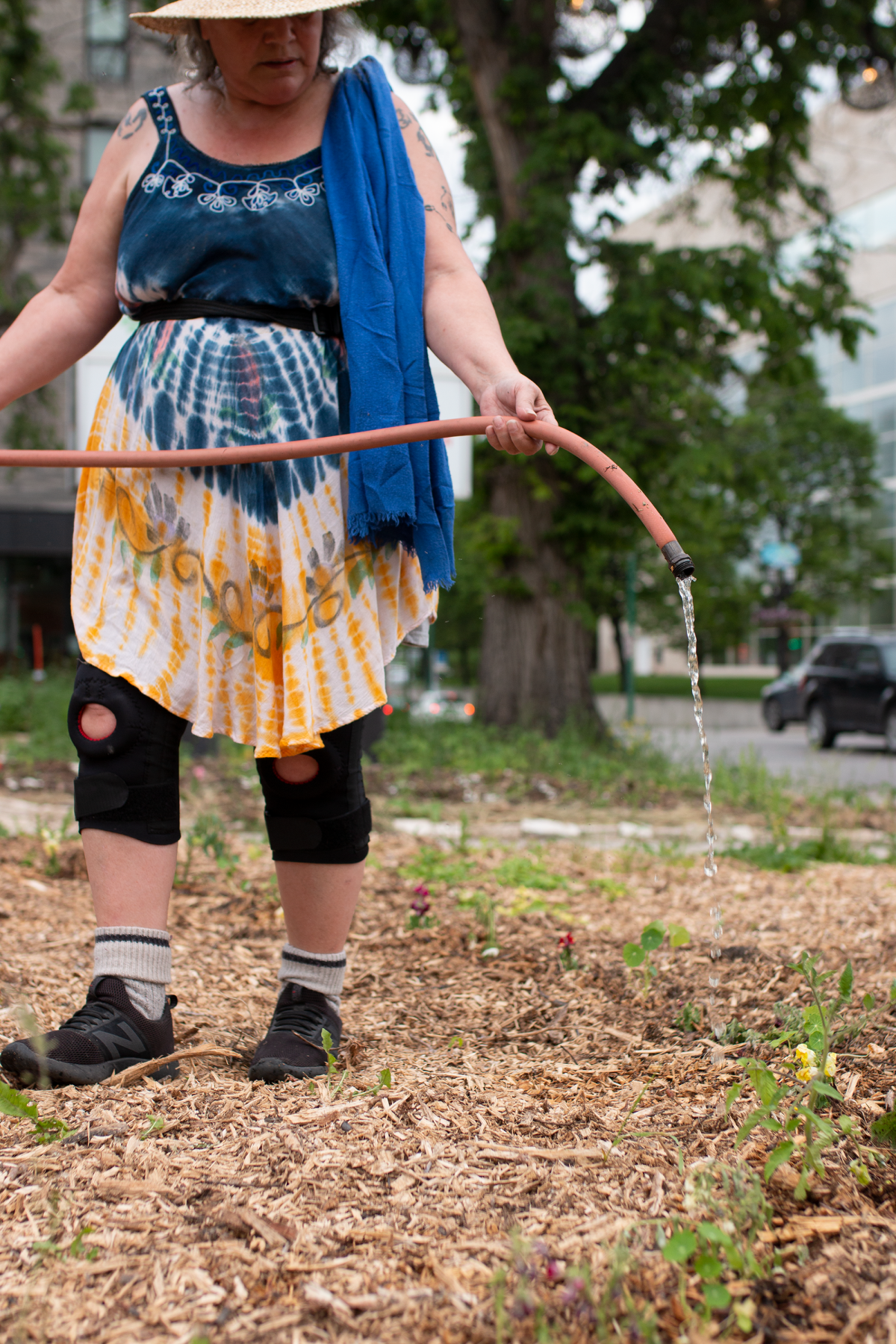 Elder Audrey Logan waters Winnipeg’s Deer Spirit Permaculture Garden on June 20, 2022.