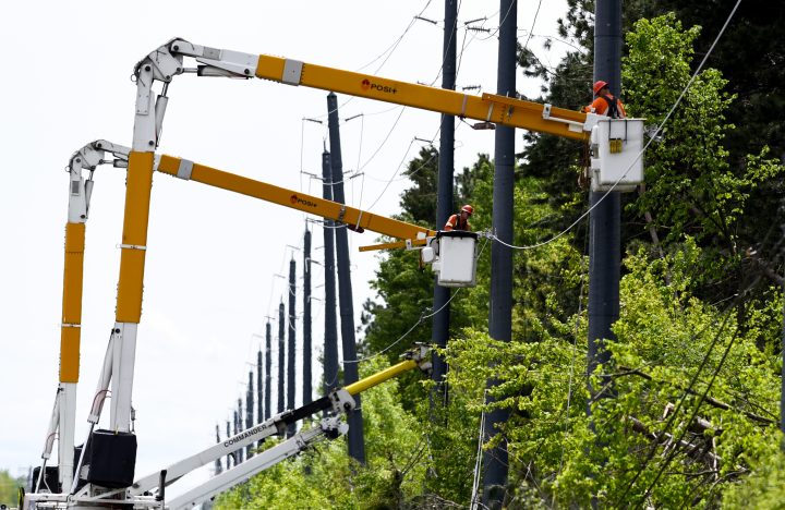 Utility workers use bucket lifts to repair lines along Hawthorne Road after a major storm caused significant damage to the city’s power distribution network in Ottawa. 